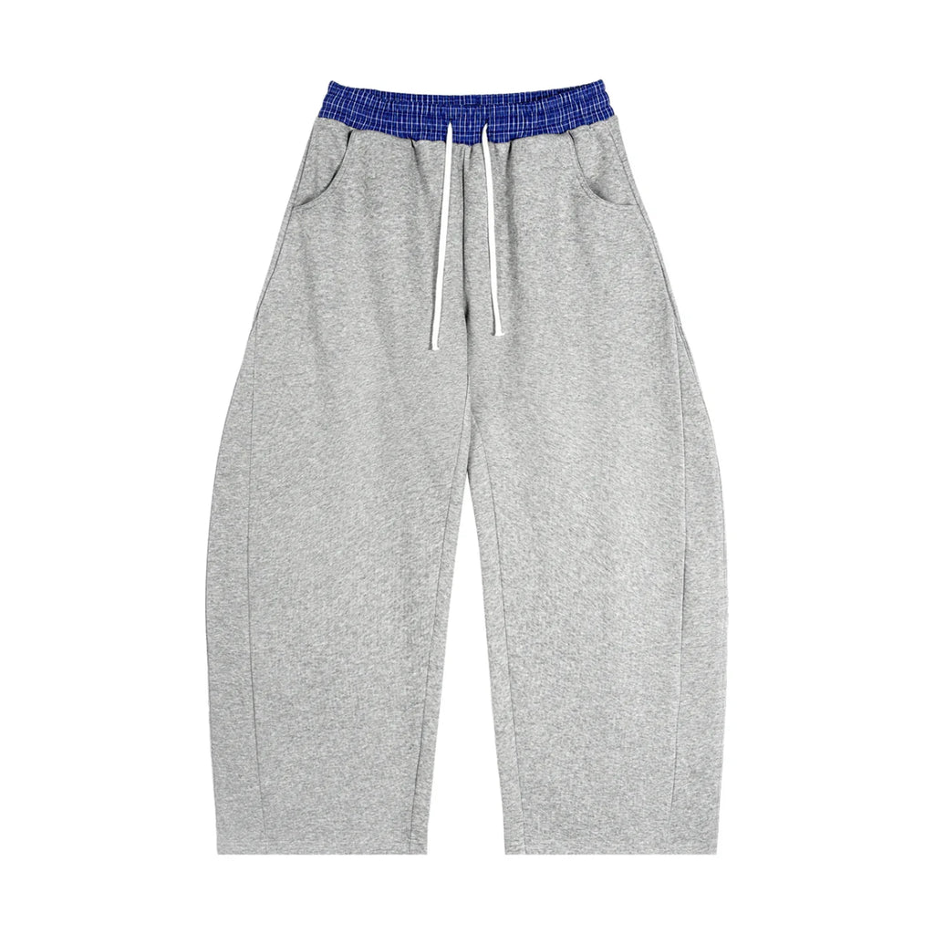 Grey oversized sweatpants with blue elastic waistband and drawstrings, streetwear style
