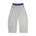 Grey oversized sweatpants with blue elastic waistband and drawstrings, streetwear style