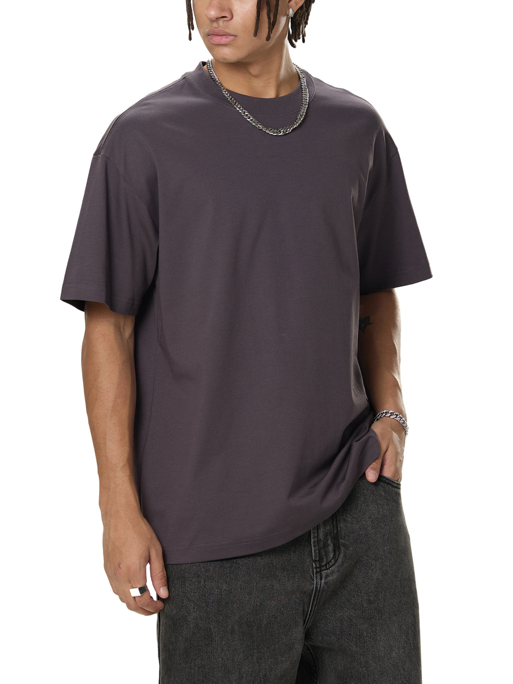 Model wearing oversized dark grey streetwear t-shirt and black jeans
