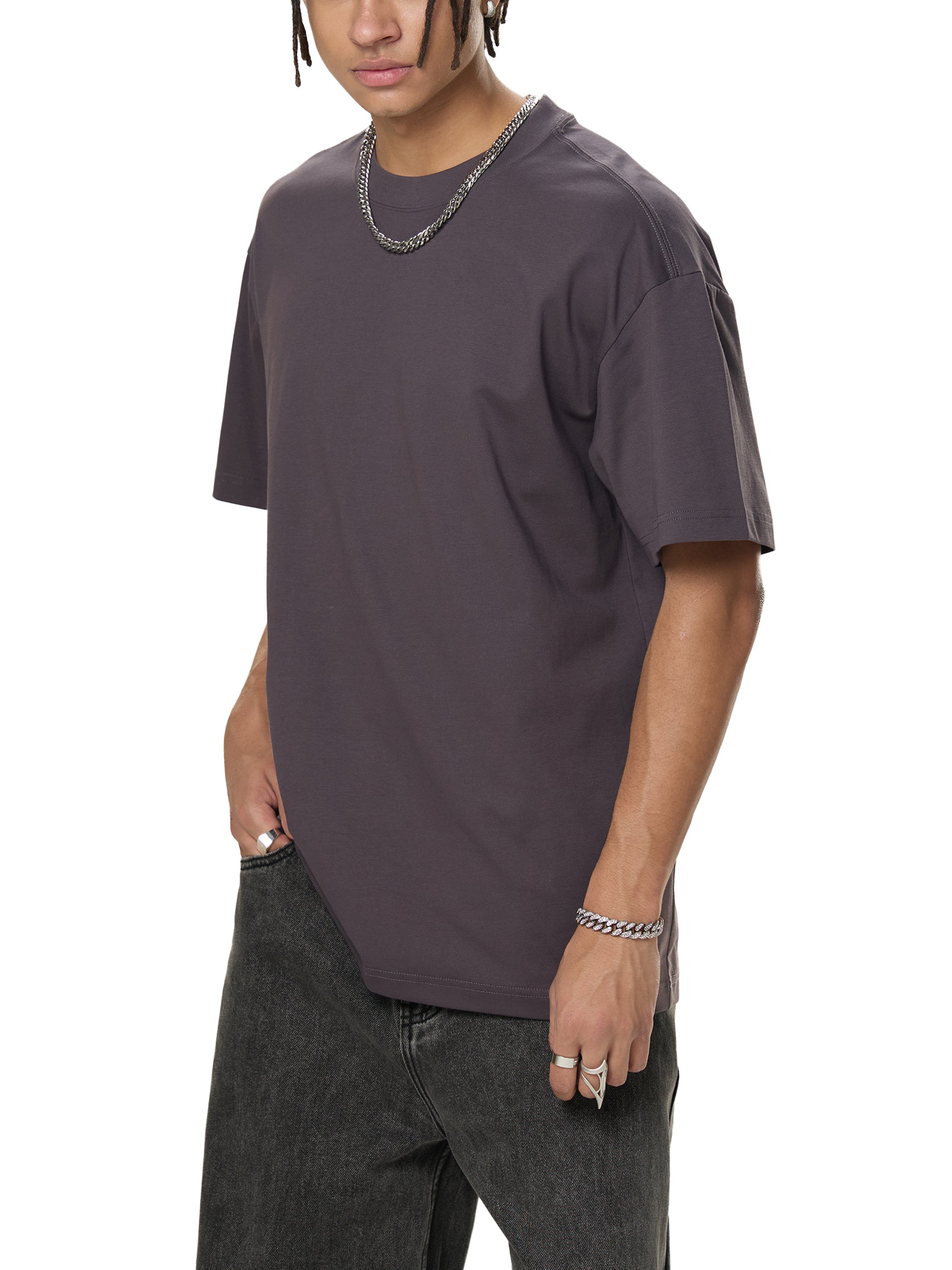 Man in oversized dark grey t-shirt and black jeans, modern streetwear style
