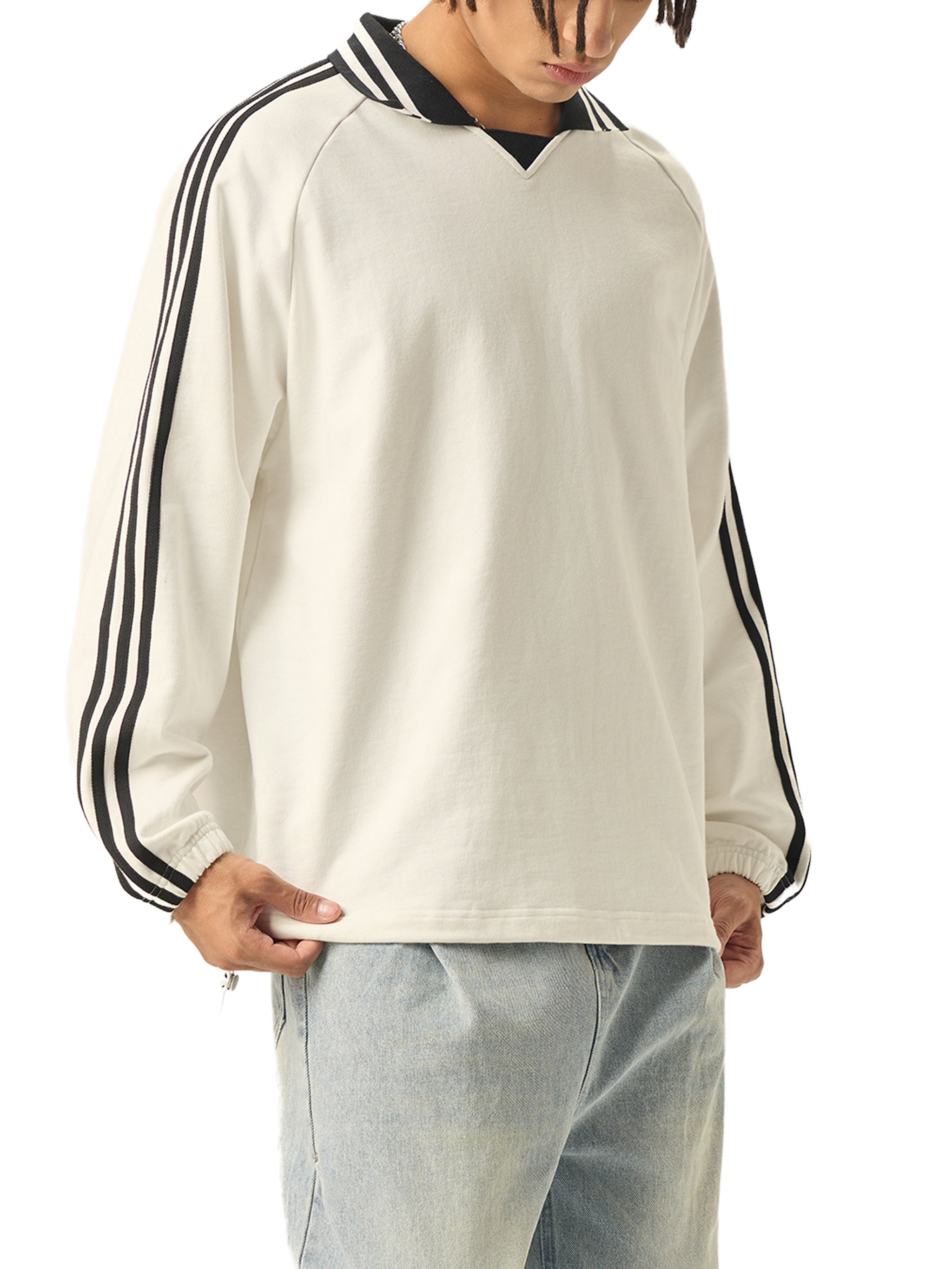 Oversized white streetwear sweatshirt with black stripes on sleeves and collar, worn with light jeans