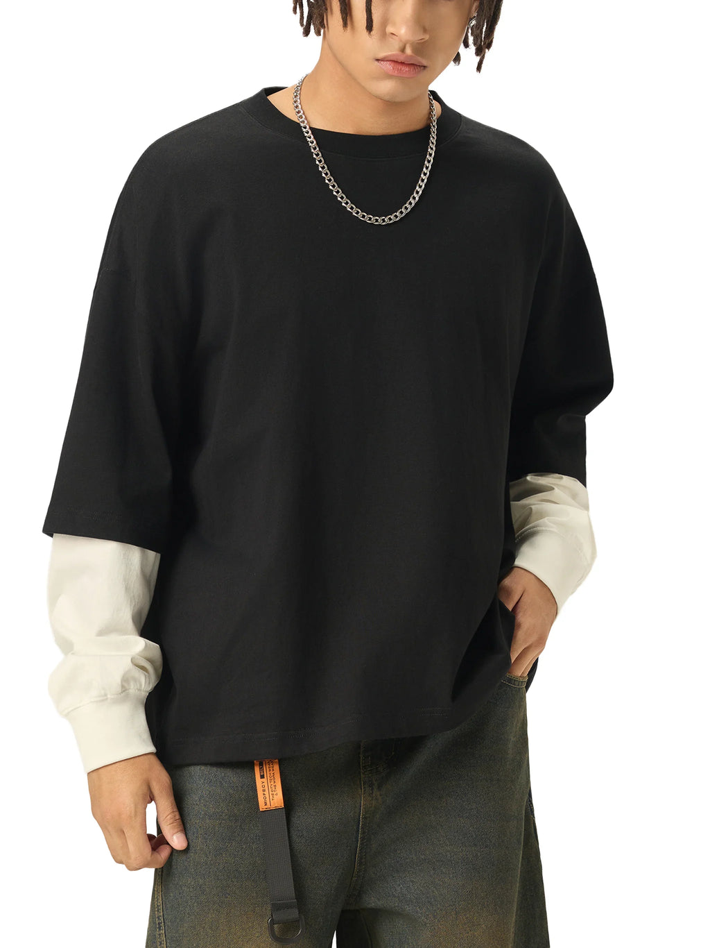 Man wearing oversized black t-shirt with white long sleeves and chain necklace, urban style