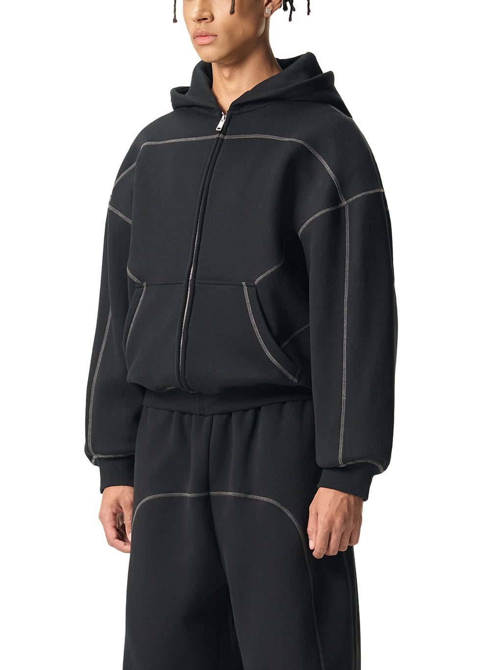 Male model in black oversized zip hoodie and matching pants with contrast stitching