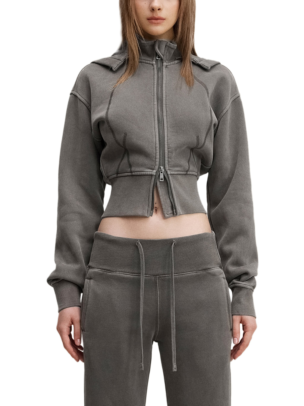 Woman wearing a grey cropped zip hoodie and matching joggers, modern streetwear style
