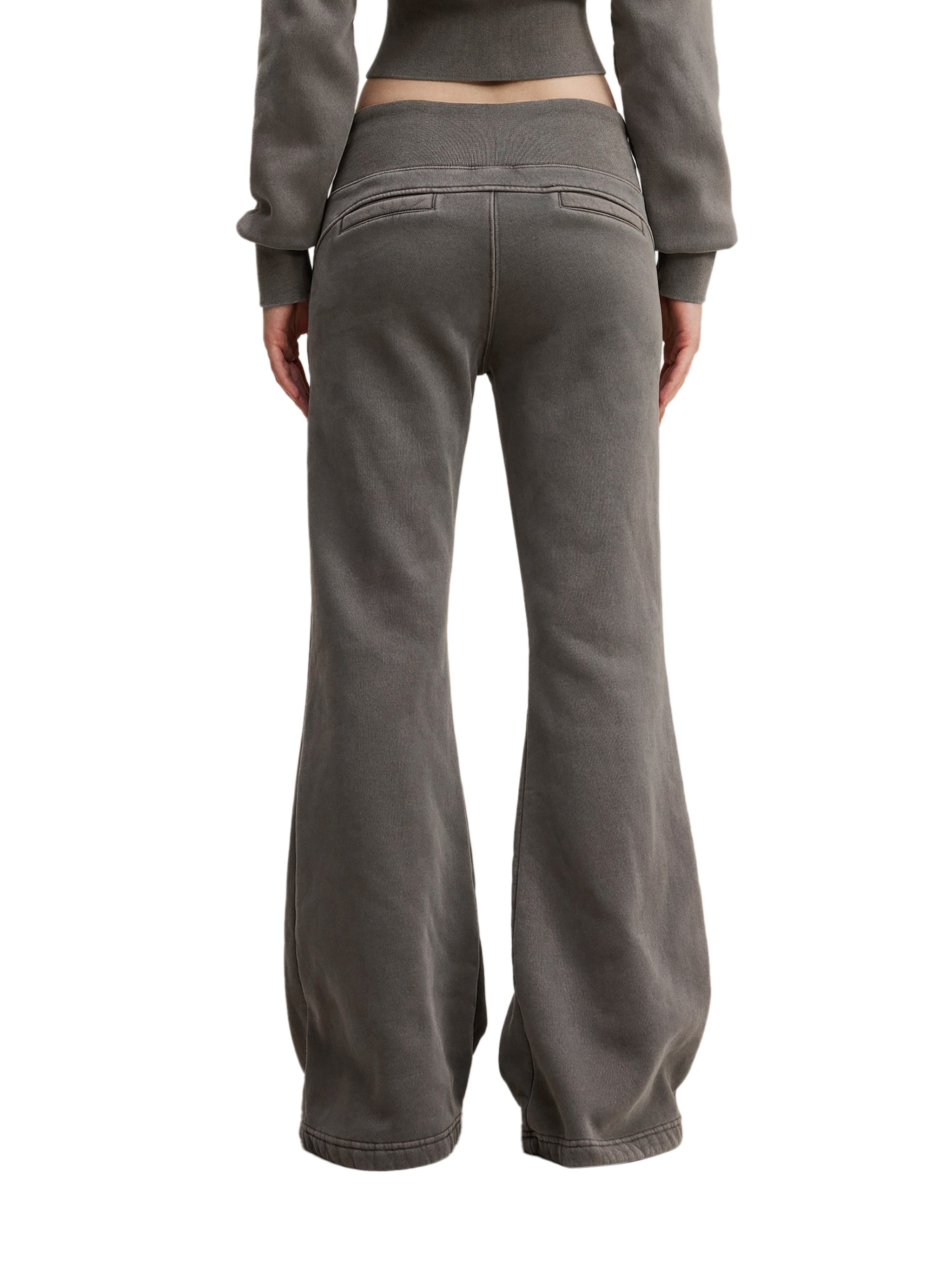 Back view of person wearing loose fit, dark gray streetwear pants with rear pockets