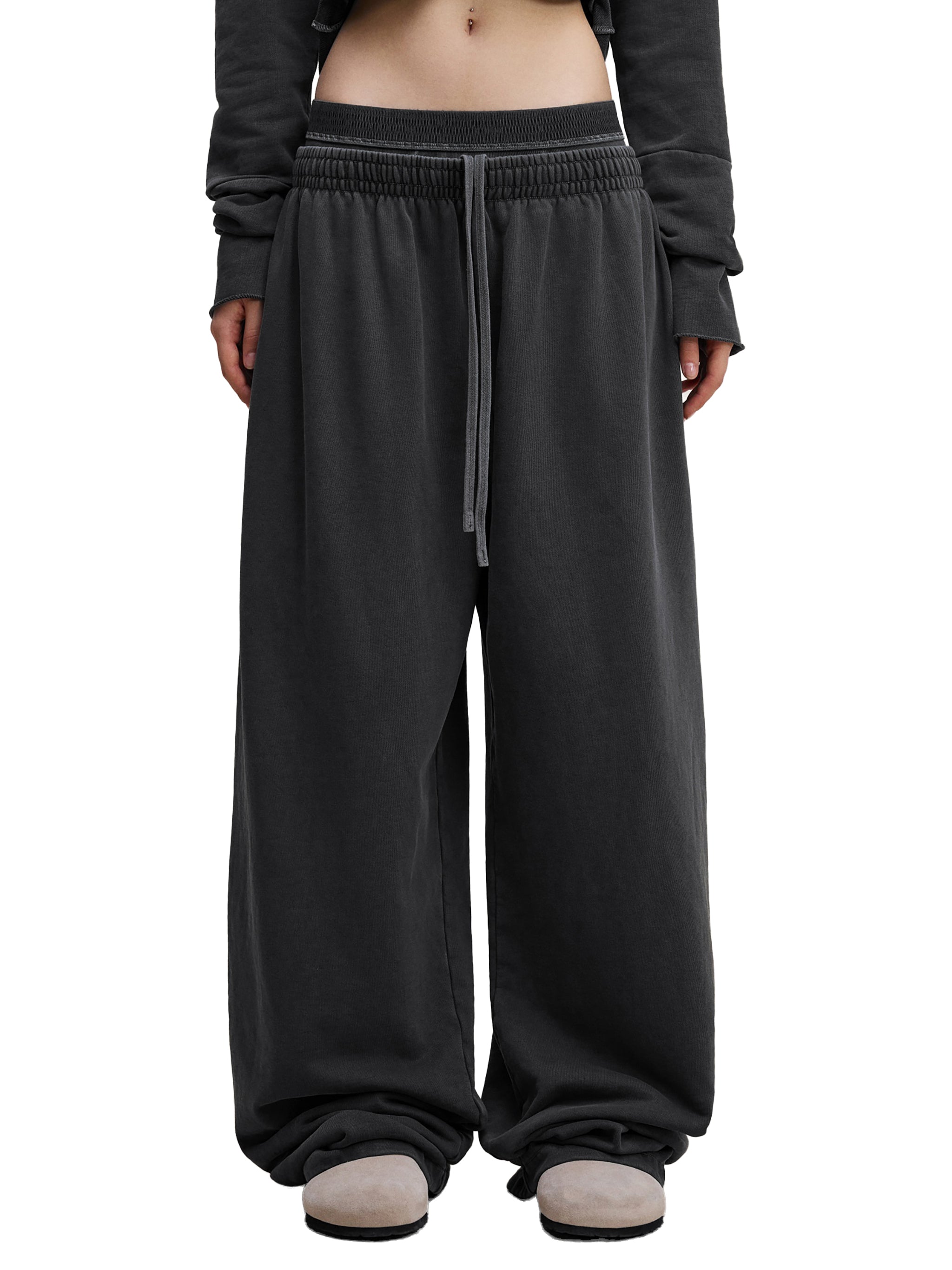 Oversized black streetwear sweatpants with elastic waistband and drawstring, urban casual style.