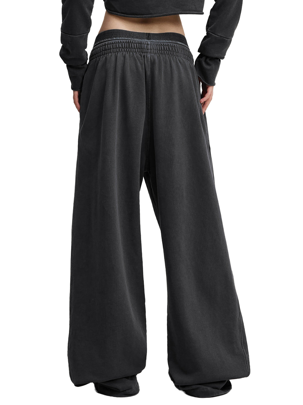 Back view of black wide-leg streetwear pants with elastic waistband, modern urban style