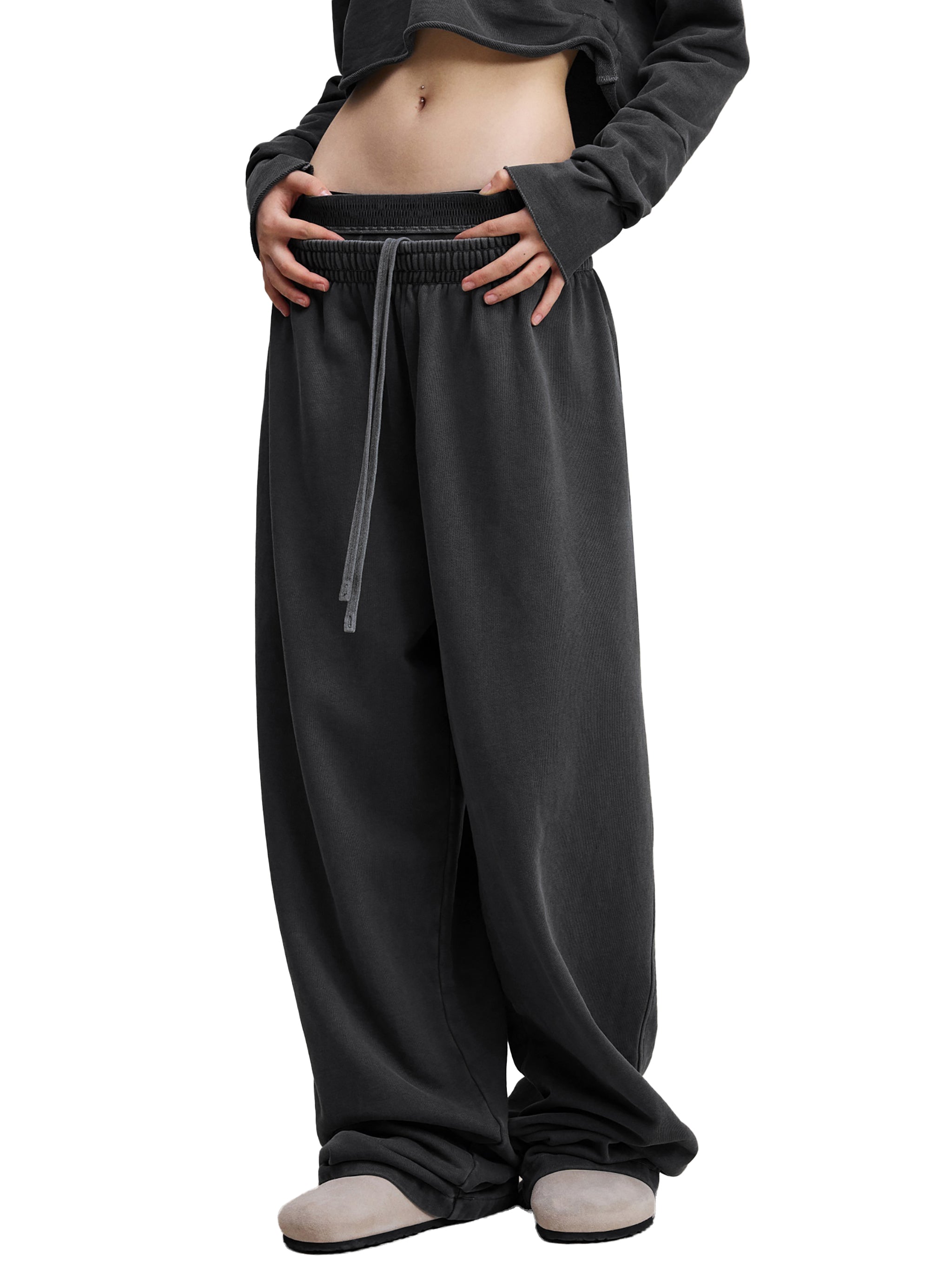 Oversized black streetwear sweatpants with drawstring waist and relaxed fit on model