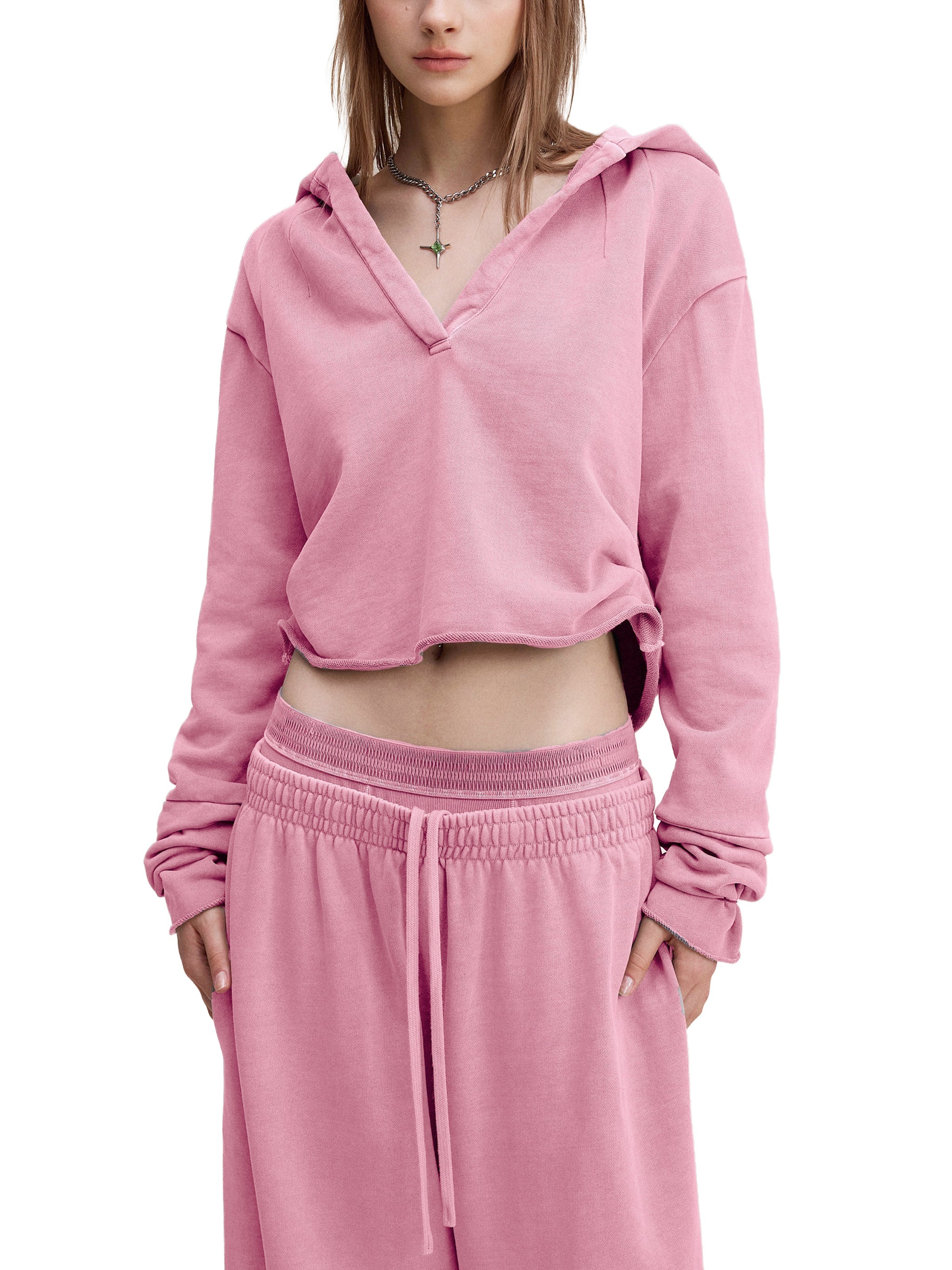 Woman wearing oversized pink cropped hoodie and matching pink sweatpants, modern streetwear style