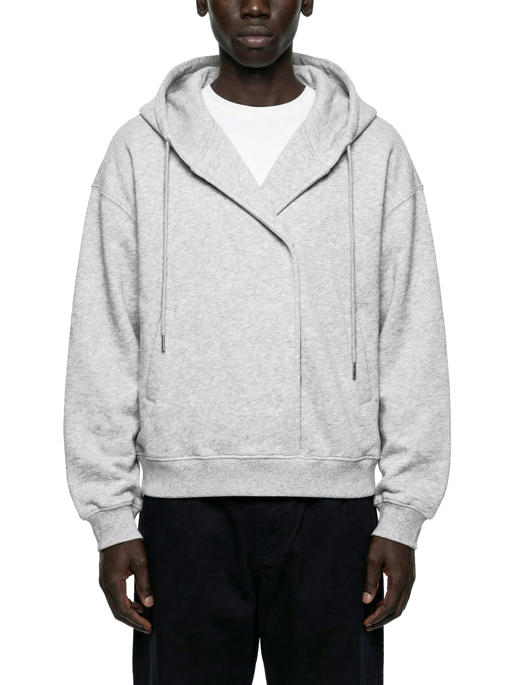 Man wearing an oversized light grey zip hoodie with drawstrings, paired with dark pants